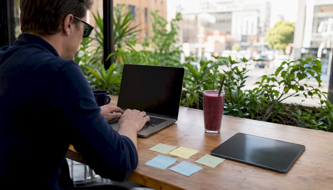Hands typing near social media metric notes on table